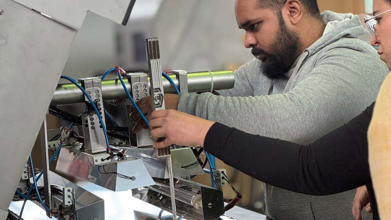 Studierende arbeiten an einer technischen Versuchsanlage und führen einen praktischen Versuch mit Mess- und Prüfelementen durch. Kabel, Sensorik und mechanische Komponenten sind sichtbar; die Teilnehmenden justieren Bauteile und überwachen den Aufbau. Das Bild steht für praxisnahe Lehre, Verfahrenstechnik, Experimentieren im Technikum und anwendungsorientierte Ausbildung im Masterstudiengang „Food Process and Product Engineering (FPPE)“.