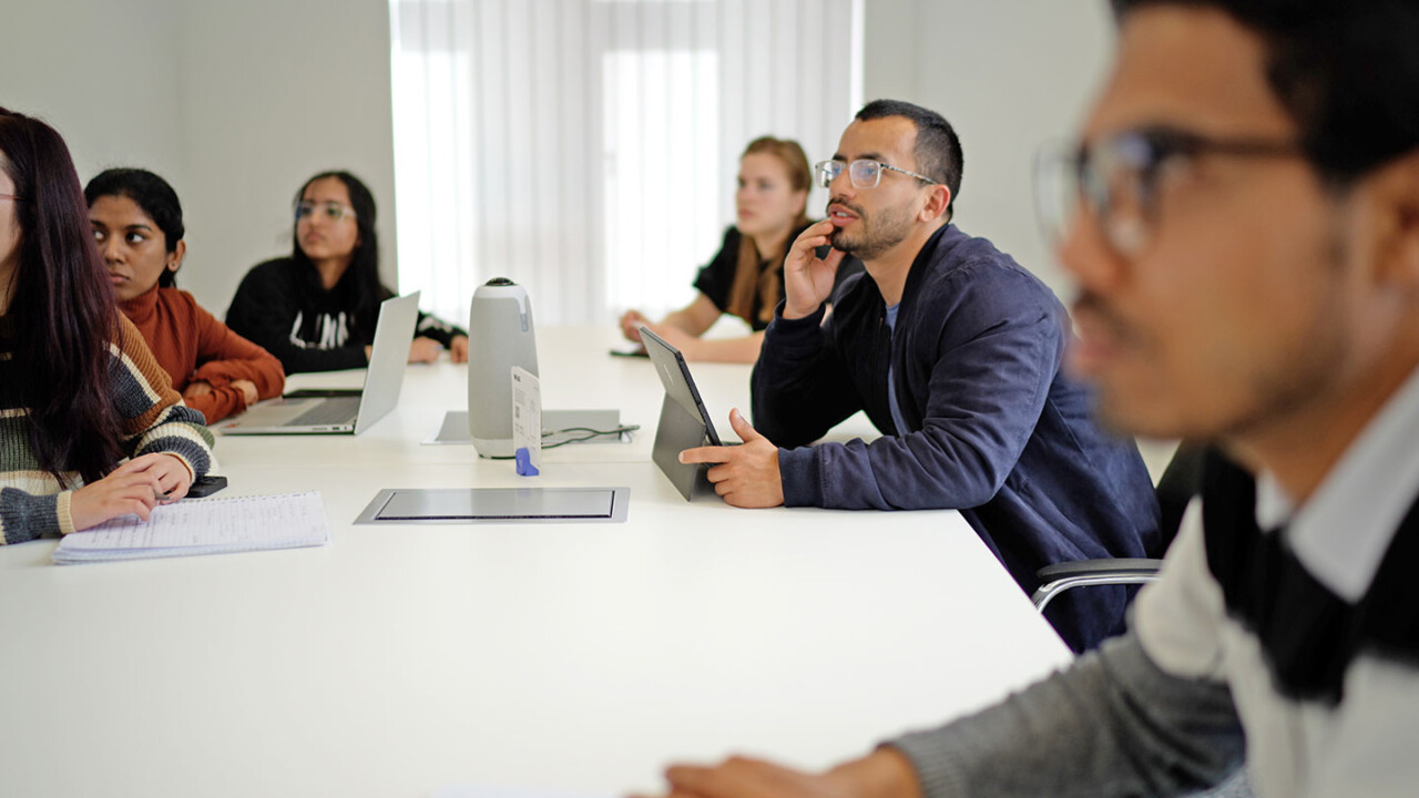 Studierende sitzen in einem Seminarraum an einem großen Tisch, hören aufmerksam zu und arbeiten mit Laptop und Tablet. Die Szene zeigt Austausch, Diskussion und gemeinsames Lernen. Das Bild steht für den Masterstudiengang „Food Process and Product Engineering (FPPE)“, praxisnahe Weiterbildung, interdisziplinäre Lehre und moderne Lernformate in der Lebensmittelwissenschaft und Prozess- bzw. Produktentwicklung.